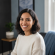 Portrait of a smiling young woman in a home office, conveying trust and customer satisfaction.